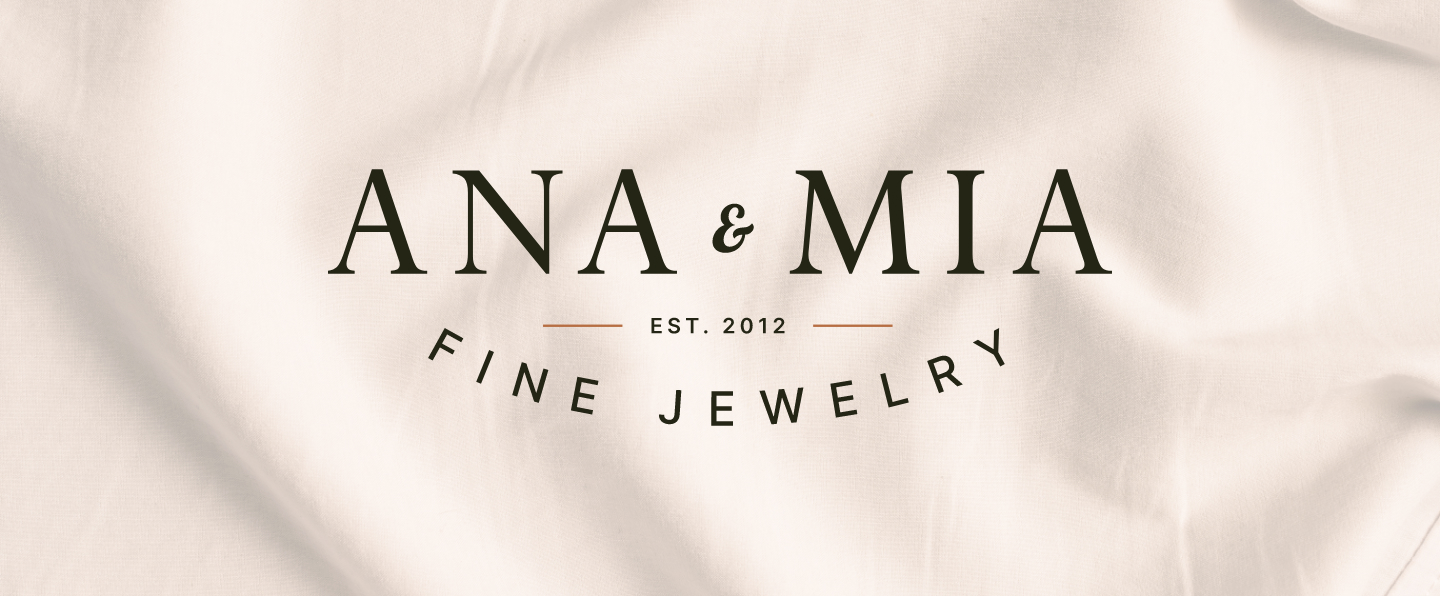 Image of full variation of Ana and Mia Fine Jewelry Logo on a background image of light fabric. Done by Stephanie Reid Designs